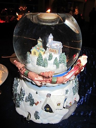 A snow globe as centerpiece provides an enchanting holiday touch to a table.